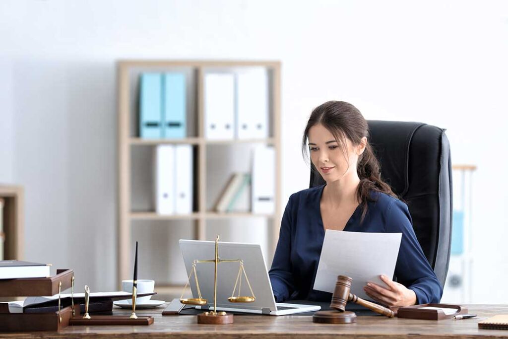 A table with legal documents, photographs, and physical evidence displayed in a courtroom setting.